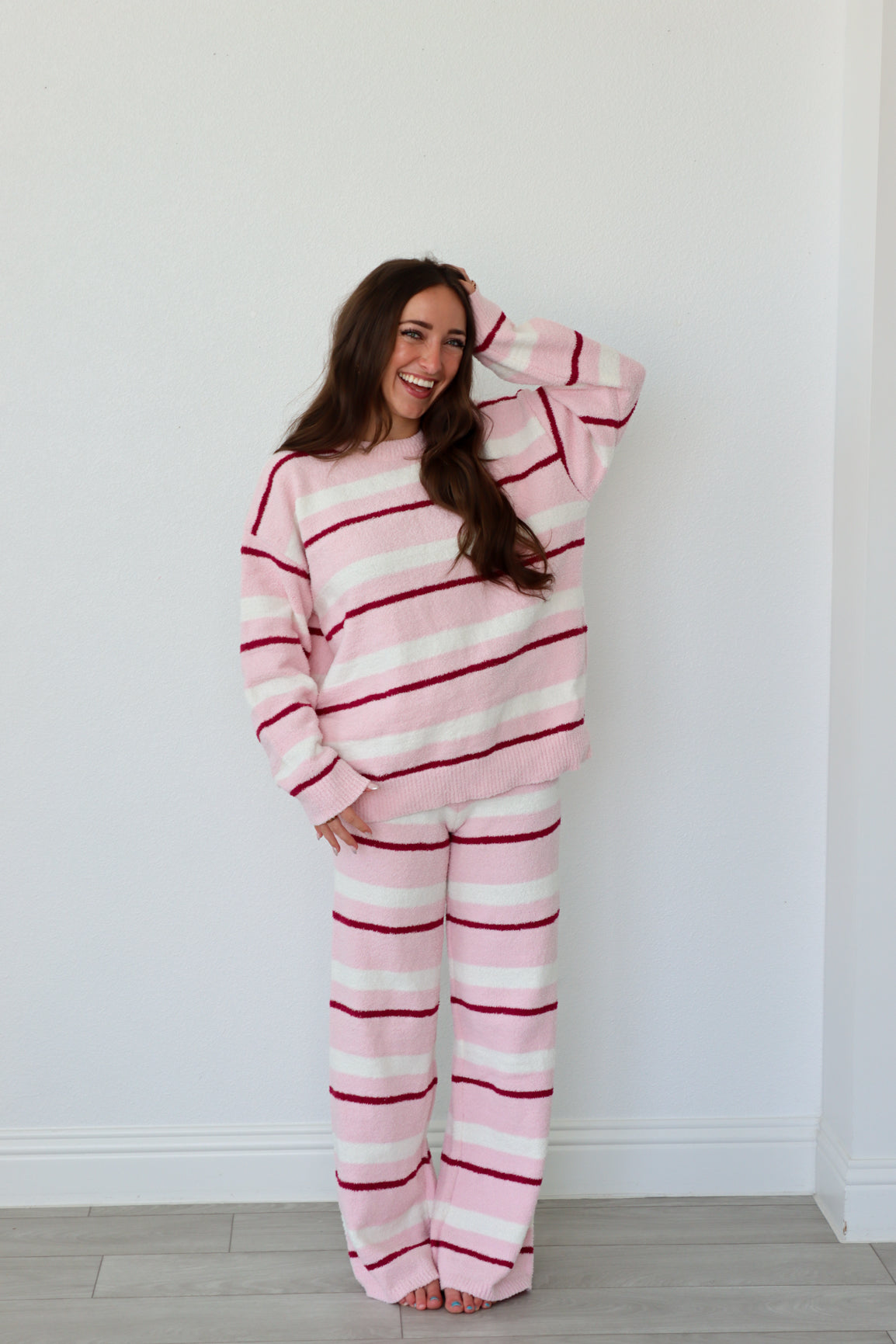 Person wearing a pink and red striped set against a white background