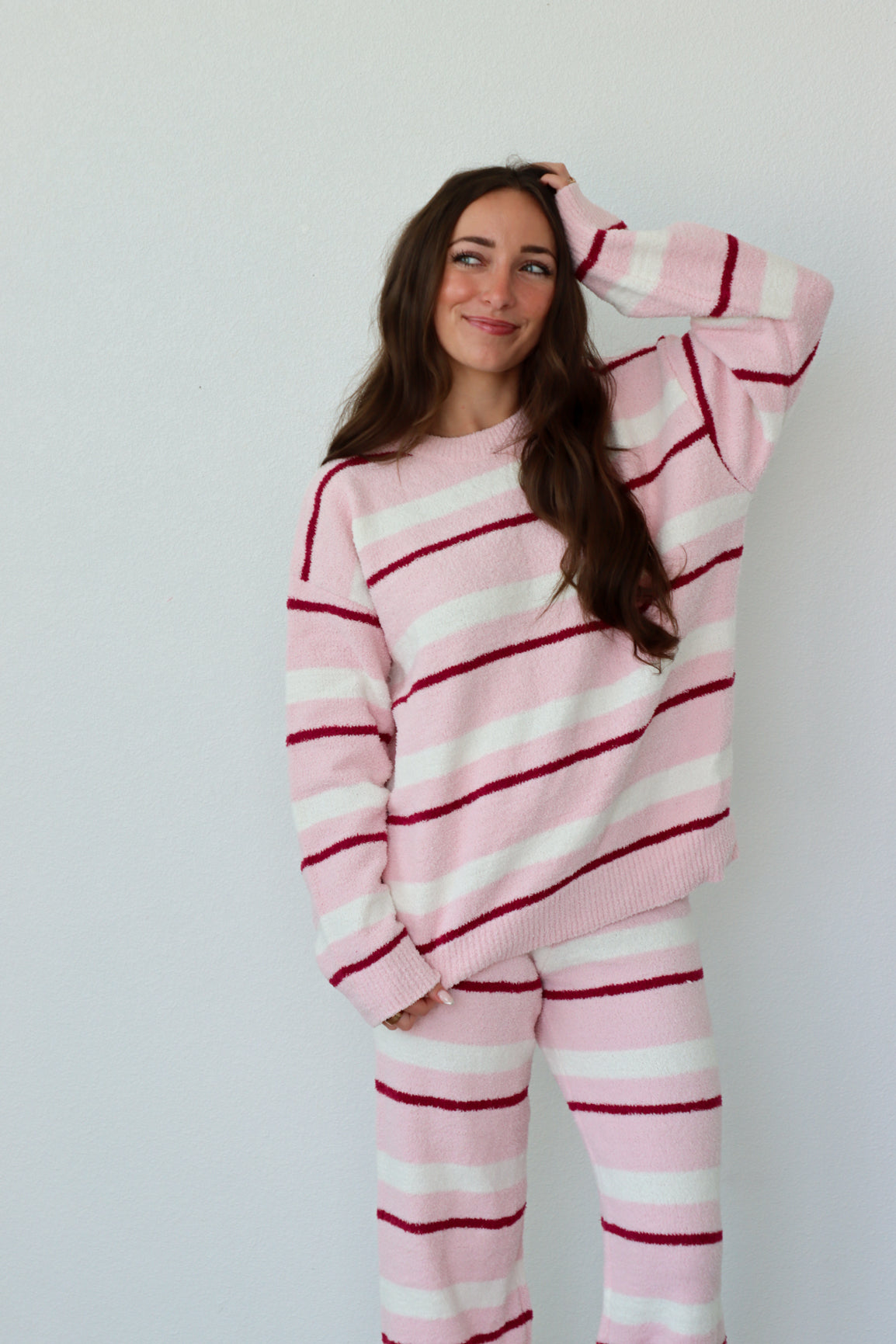 Person wearing pink and white striped set against a plain background
