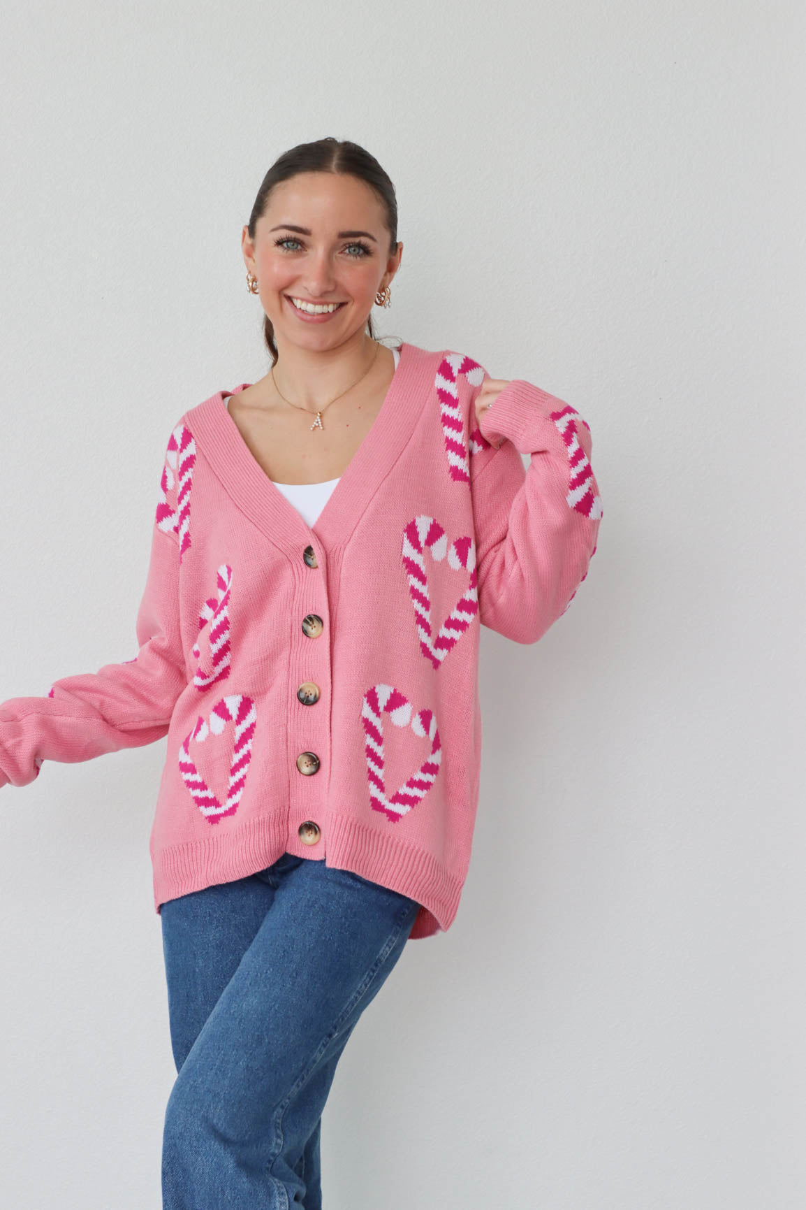 girl wearing pink candy cane cardigan