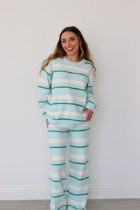 Woman wearing a light blue and white striped set against a white background