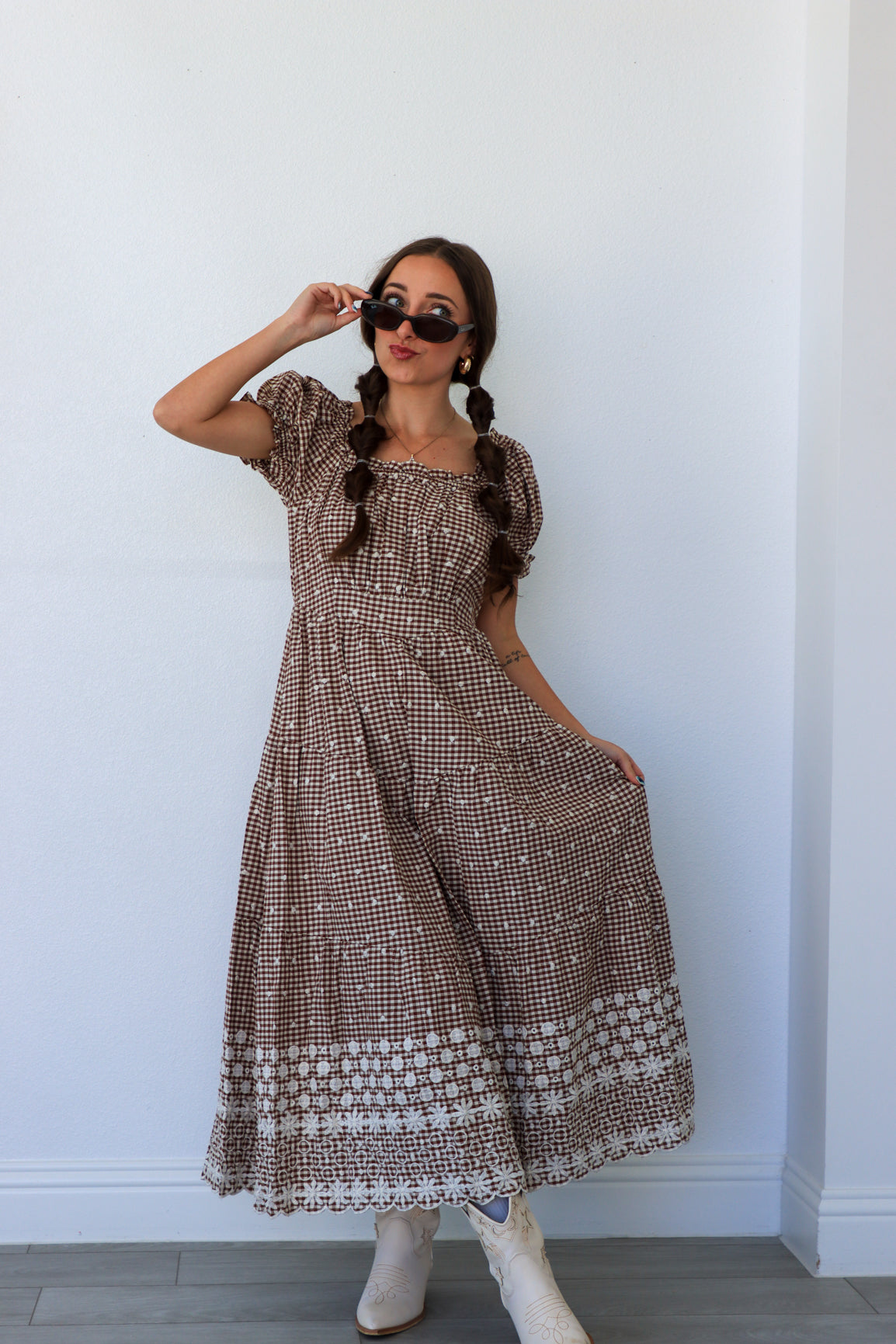 Woman wearing a patterned dress against a white wall