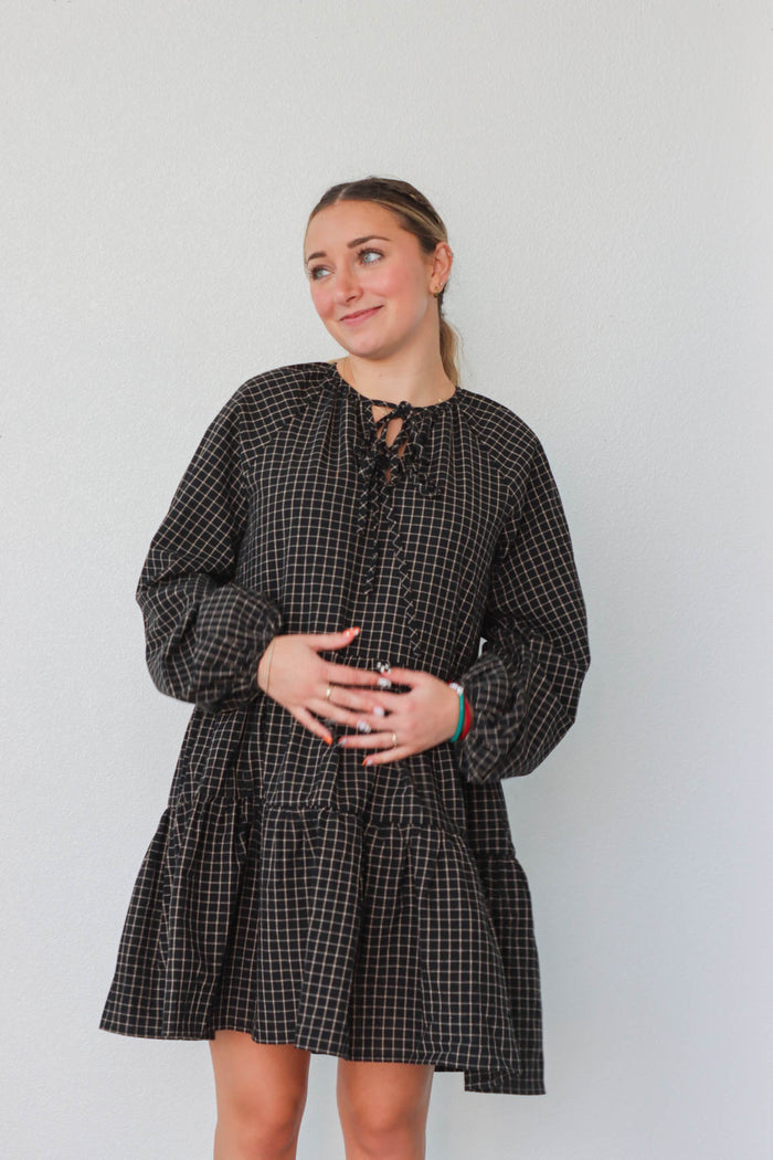 girl wearing black plaid long sleeve dress