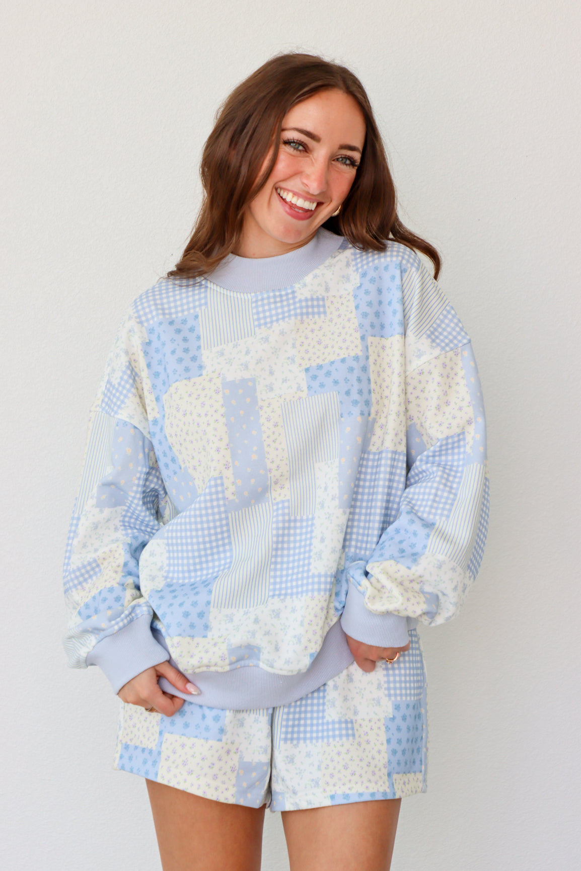 Woman wearing a blue and white outfit against a plain background