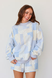 Woman wearing a blue and white outfit against a plain background