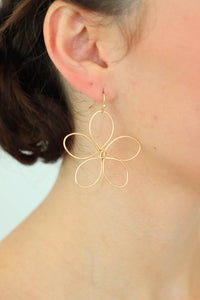 girl wearing gold flower earrings