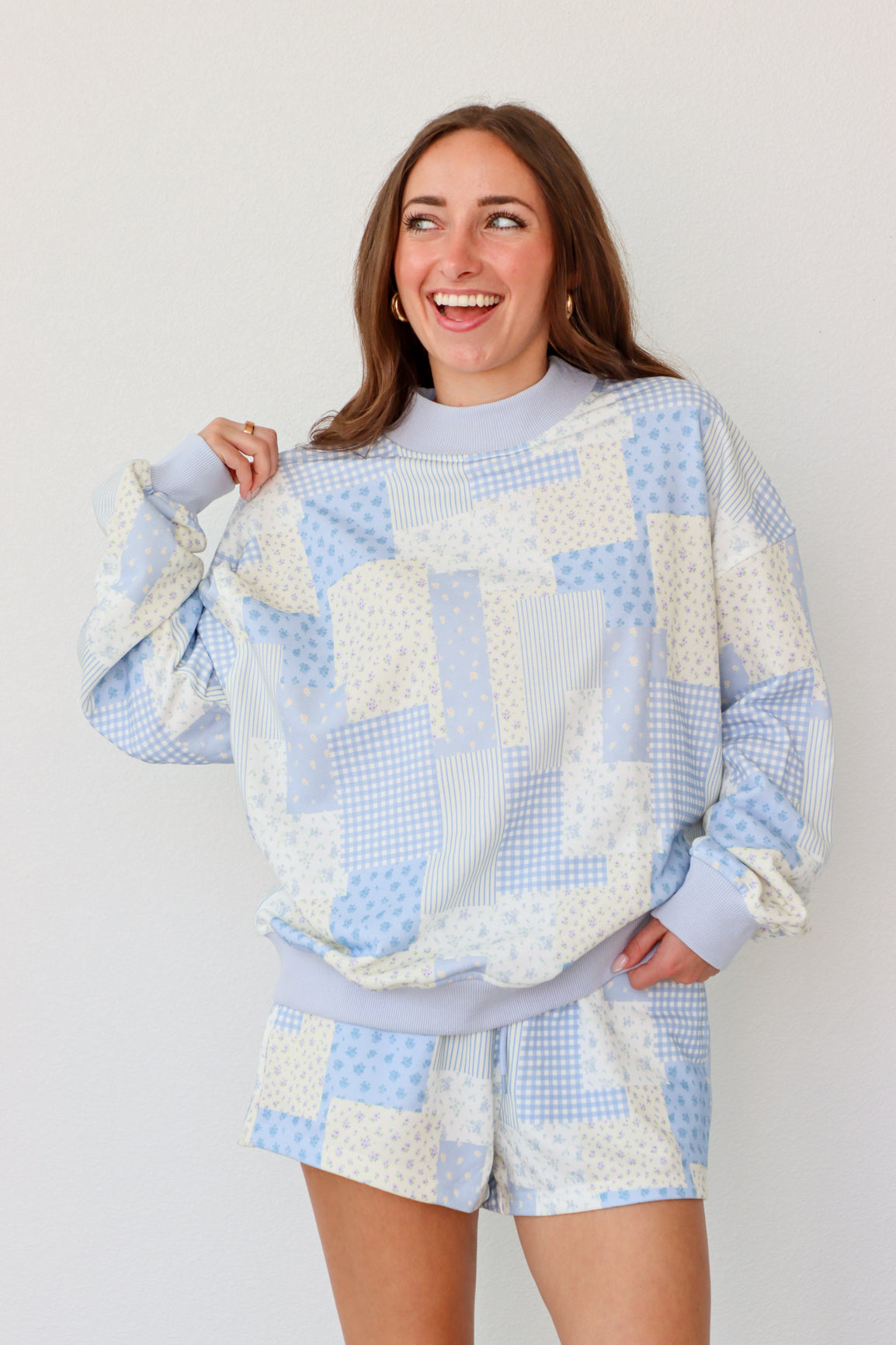 Woman wearing a blue and white outfit against a plain background