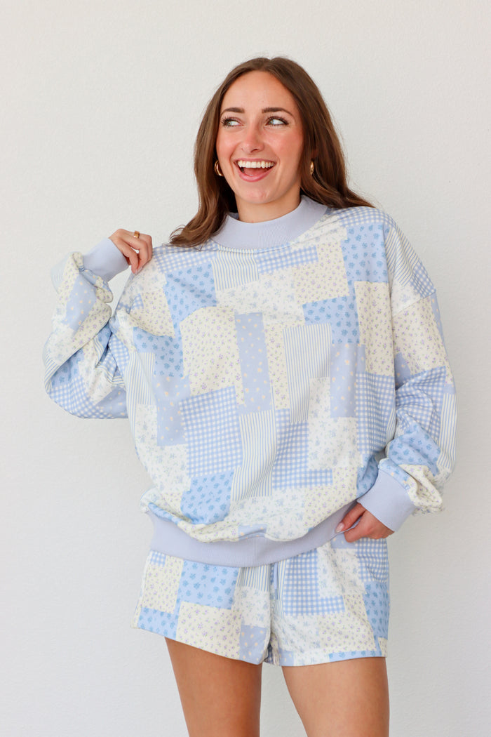 Woman wearing a blue and white outfit against a plain background