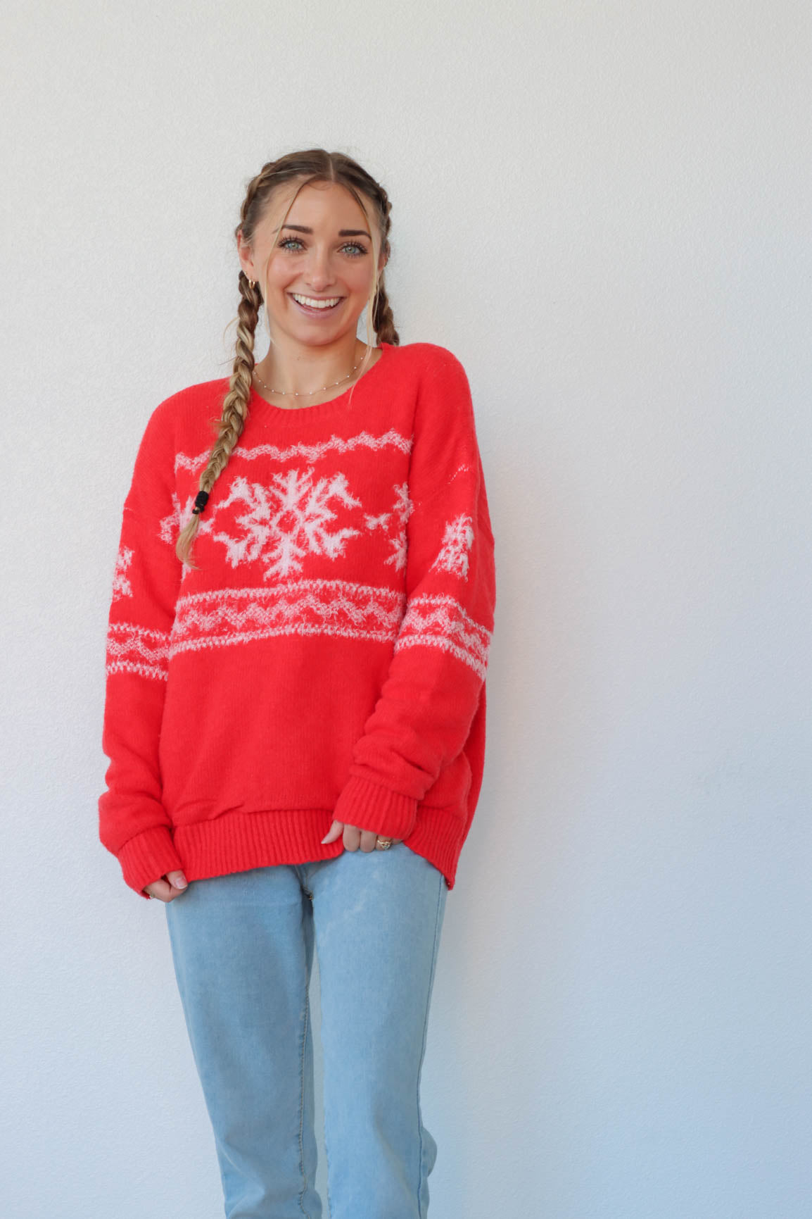 girl wearing red sweater with white snow flake pattern