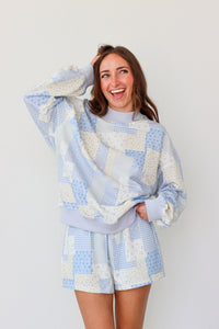 Woman wearing a blue and white outfit against a plain background.