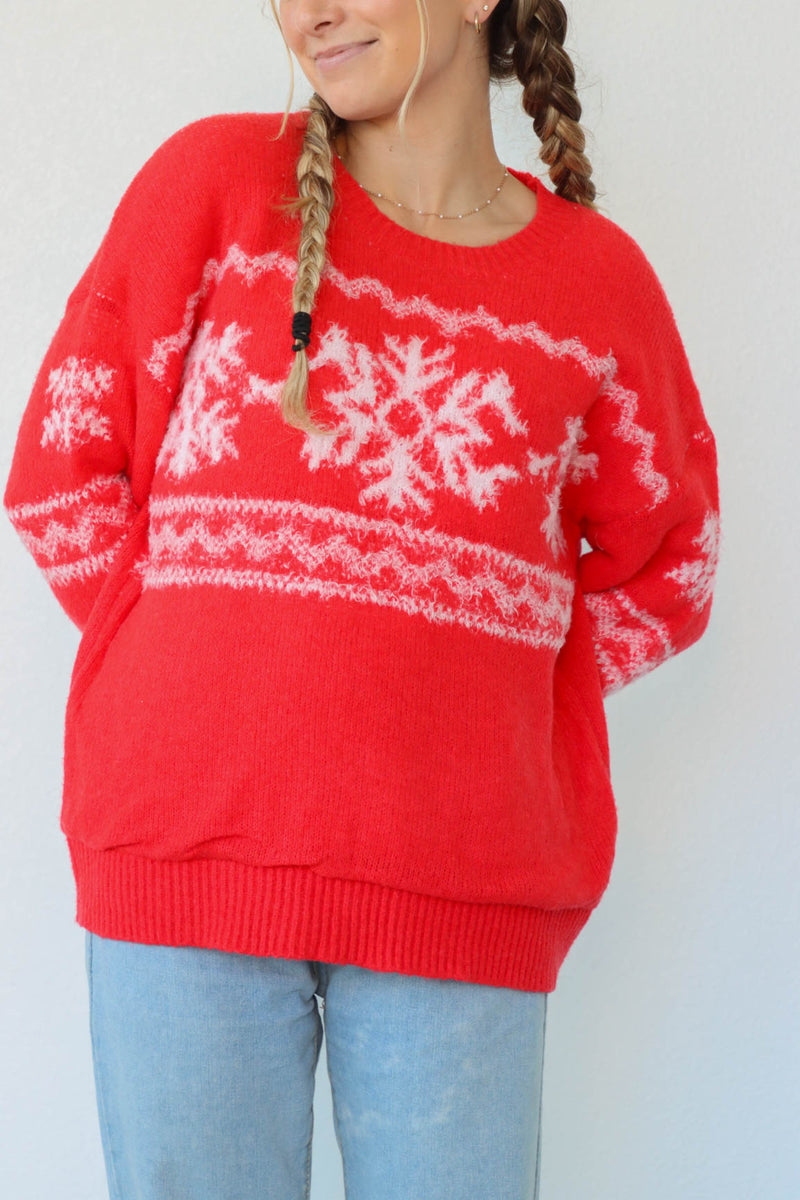 girl wearing red sweater with white snow flake pattern