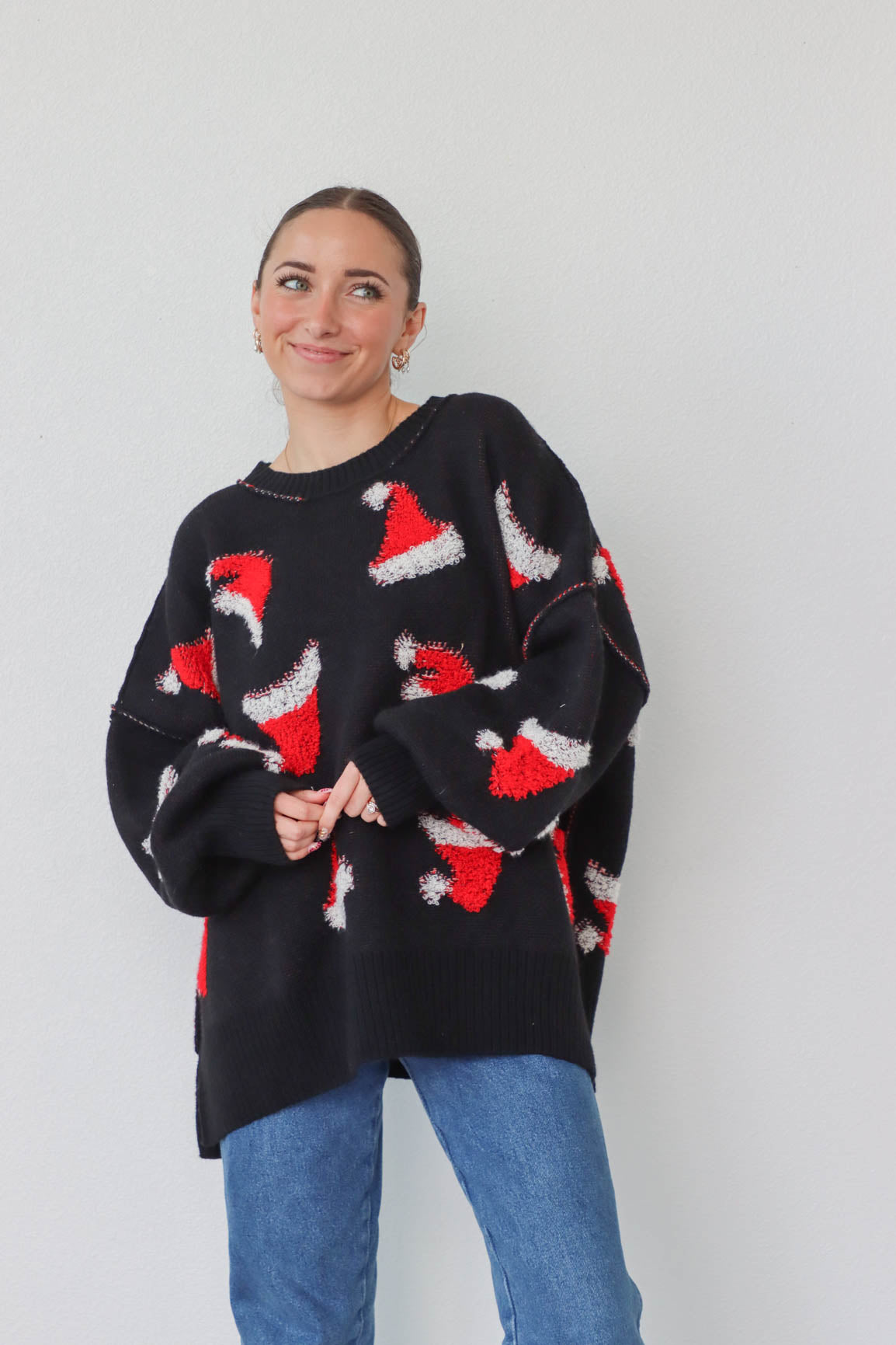 girl wearing black sweater with red santa hat pattern