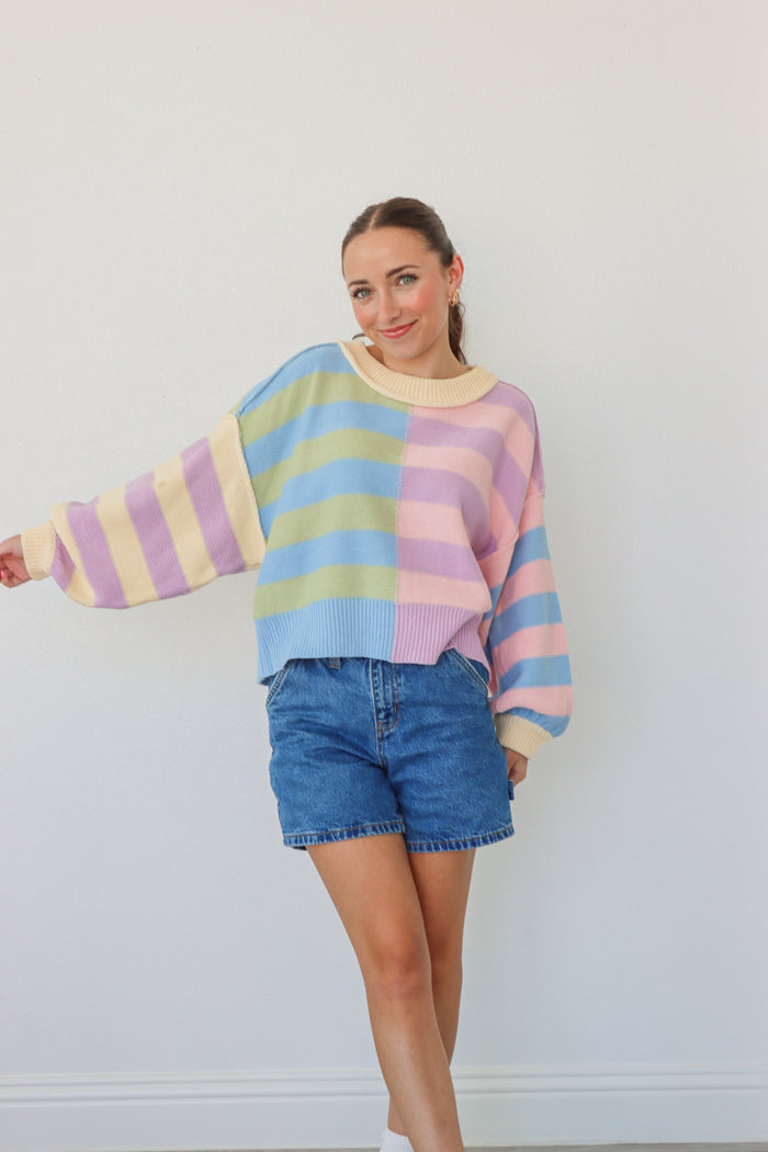 girl wearing pastel multicolor striped knit sweater