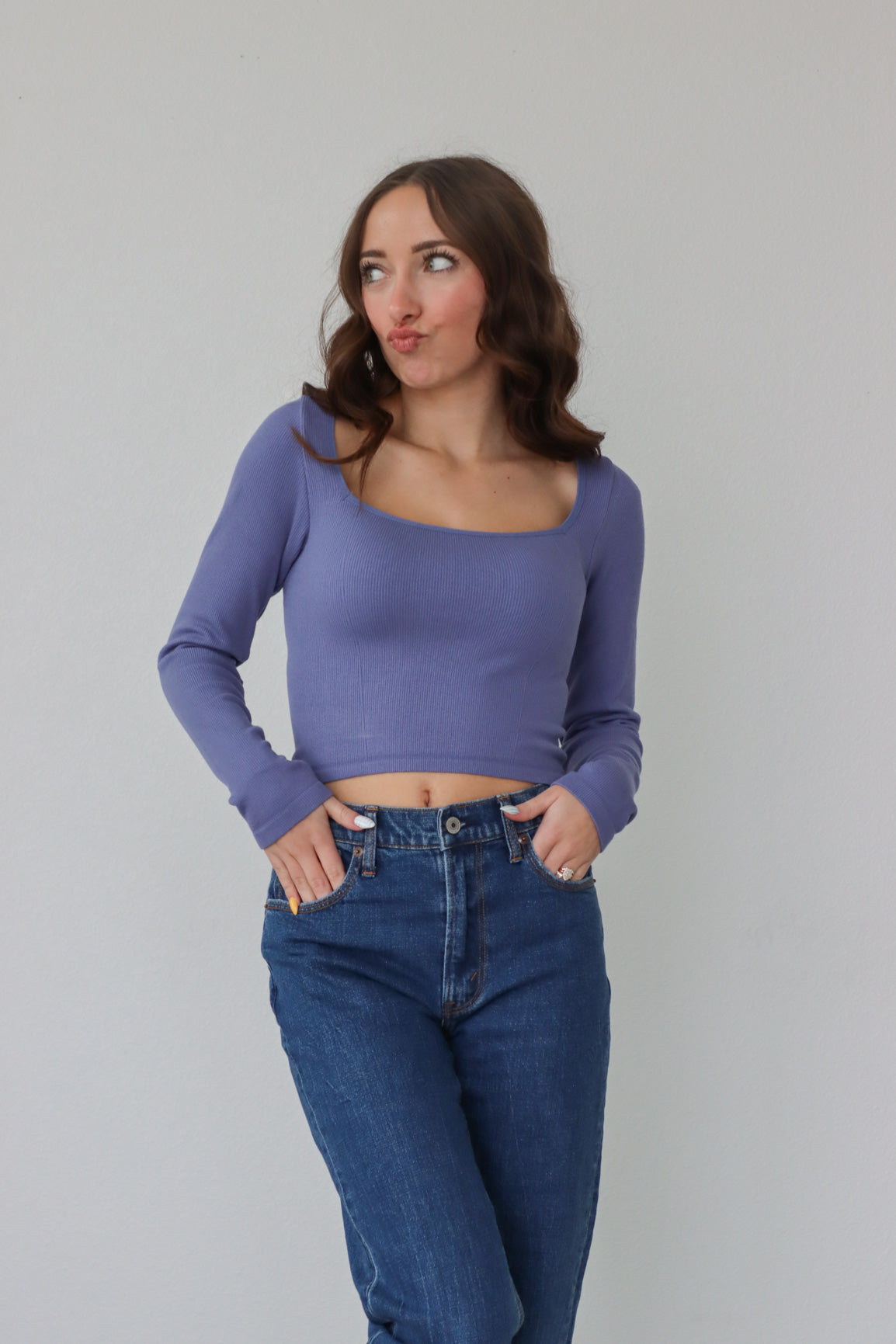 girl wearing purple square neck, long sleeved top
