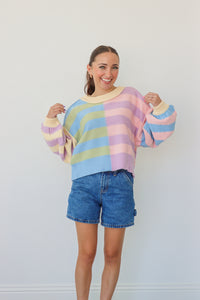 girl wearing pastel multicolor striped knit sweater