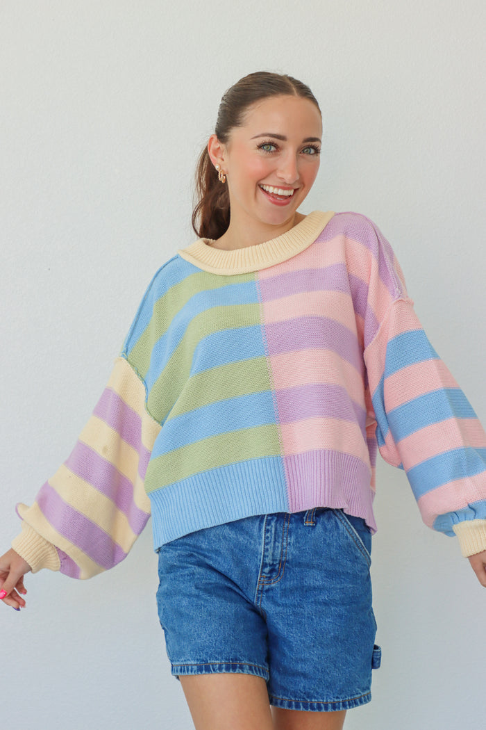 girl wearing pastel multicolor striped knit sweater