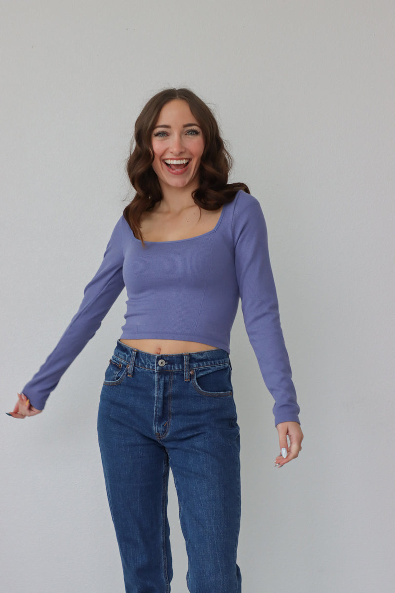 girl wearing purple square neck, long sleeved top