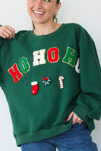 girl wearing dark green "ho ho ho" crewneck