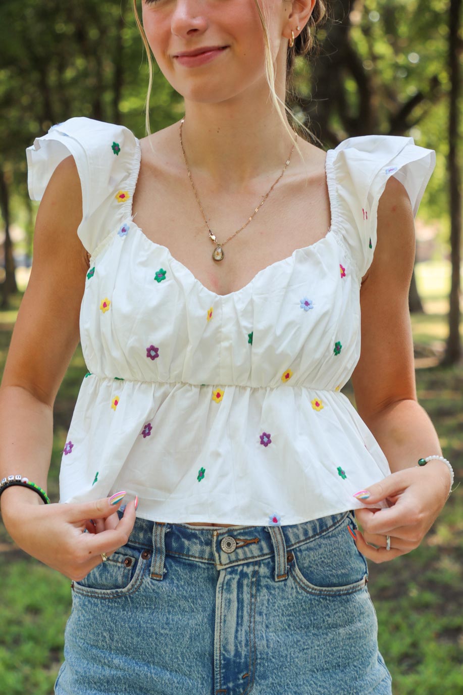girl wearing white puff sleeve top with multicolored embroidered flowers