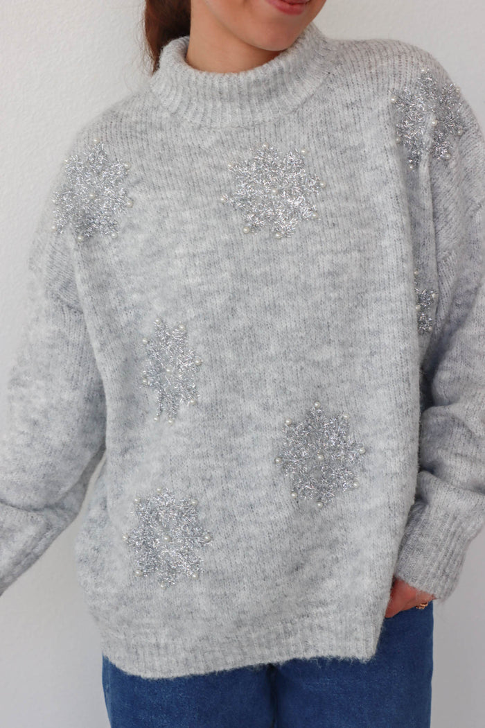 girl wearing gray sparkly snowflake sweater