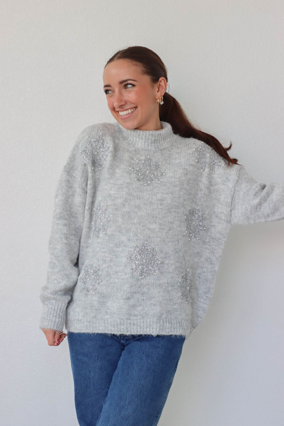 girl wearing gray sparkly snowflake sweater