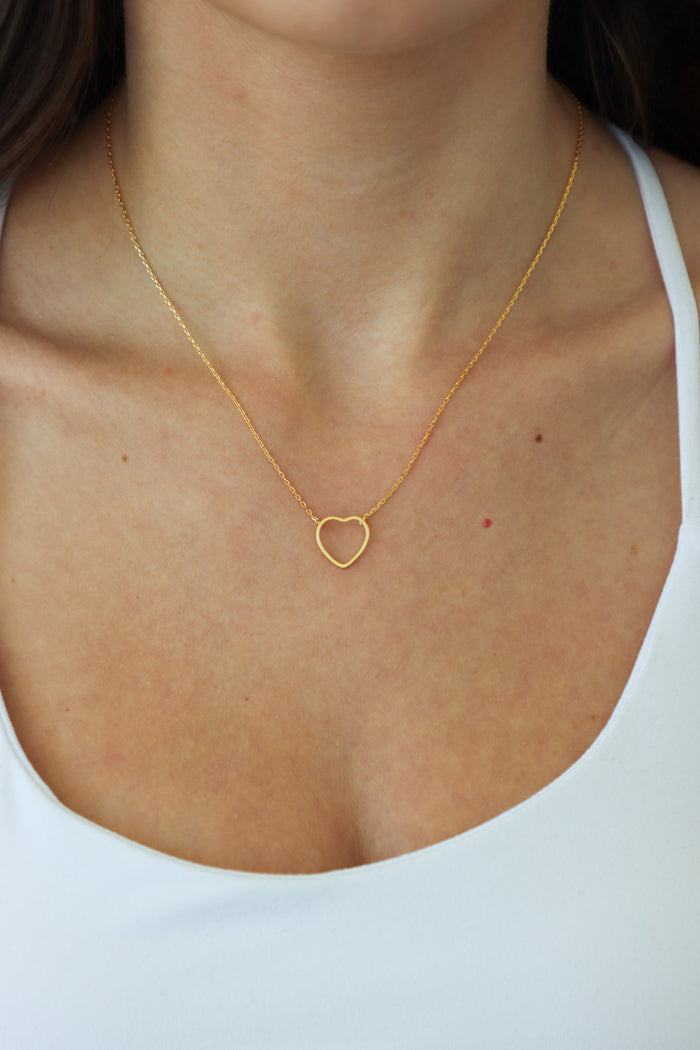girl wearing gold heart necklace