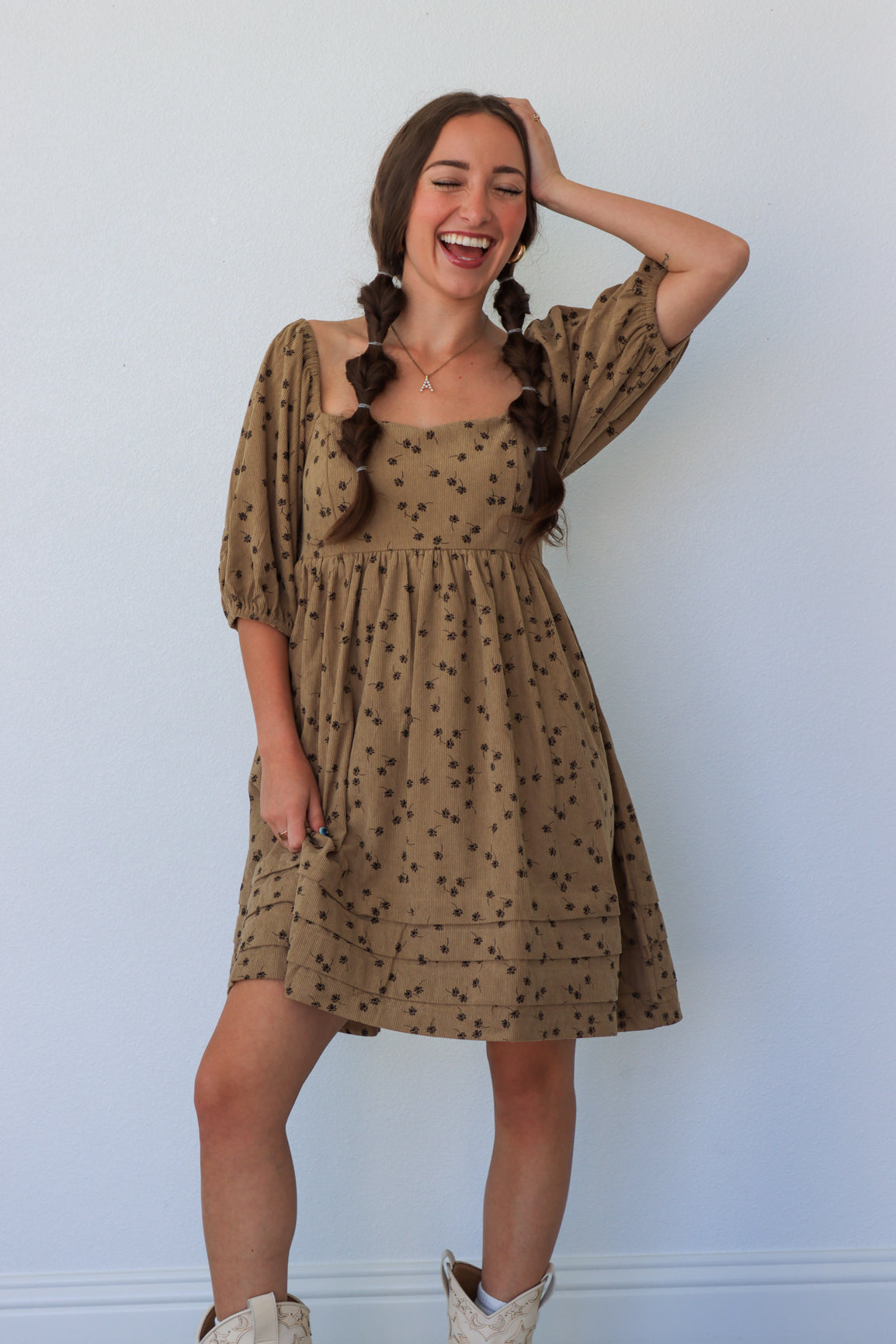 Woman wearing a patterned dress against a plain background