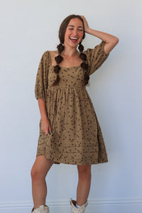 Woman wearing a patterned dress against a plain background