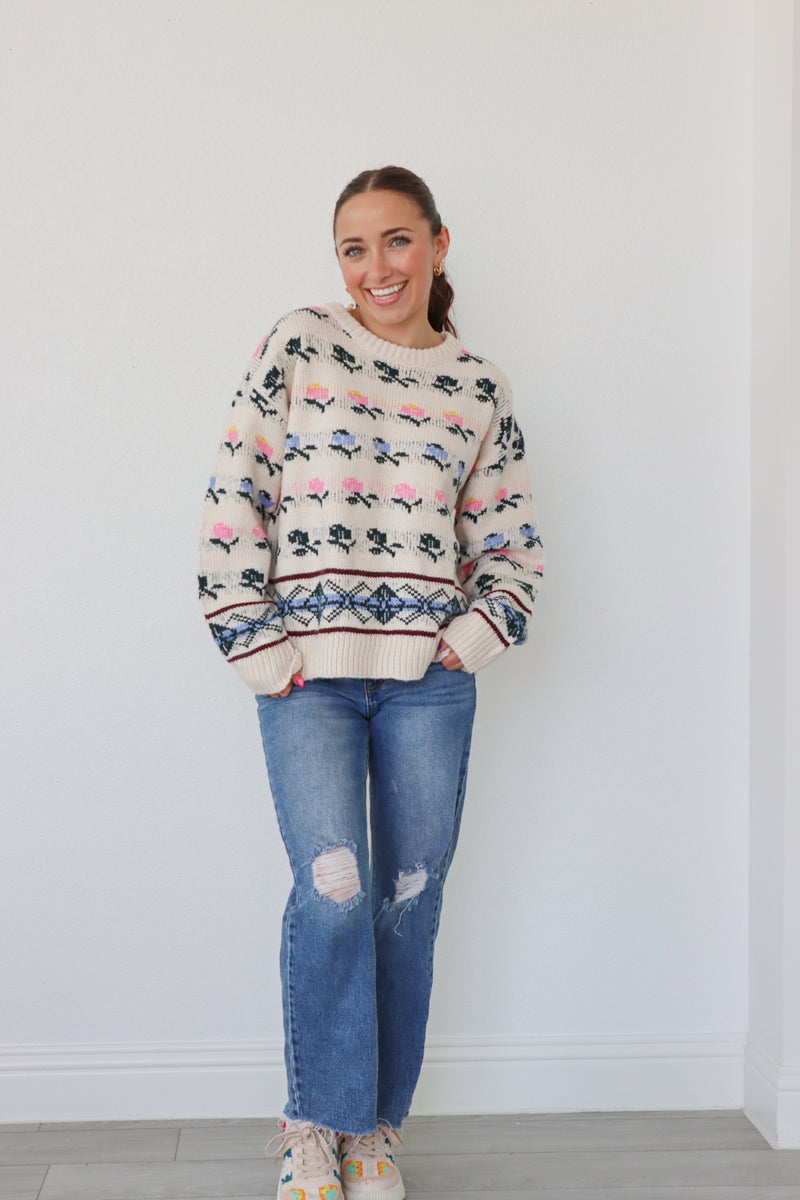 girl wearing cream knit sweater with floral detailing