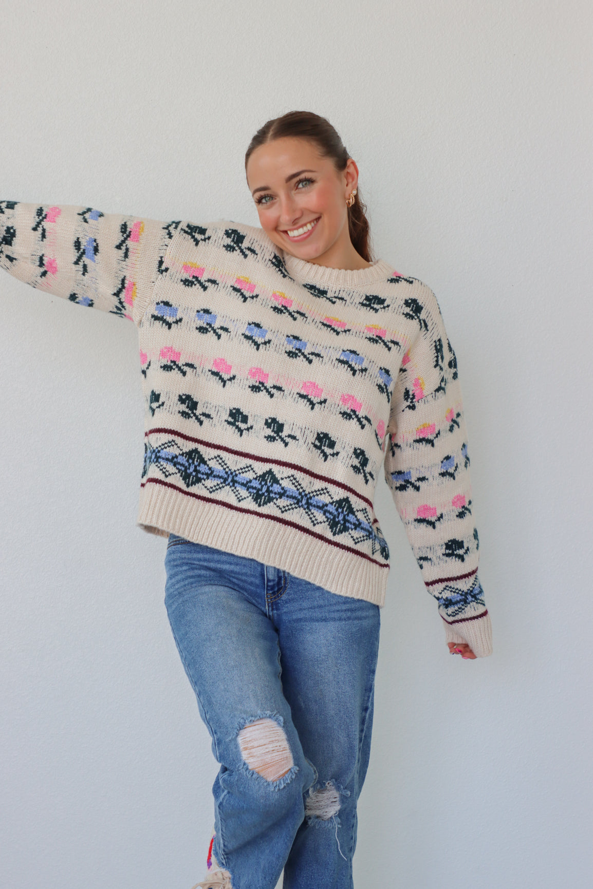 girl wearing cream knit sweater with floral detailing