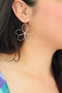 girl wearing silver flower earrings