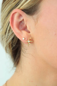 girl wearing gold star earrings