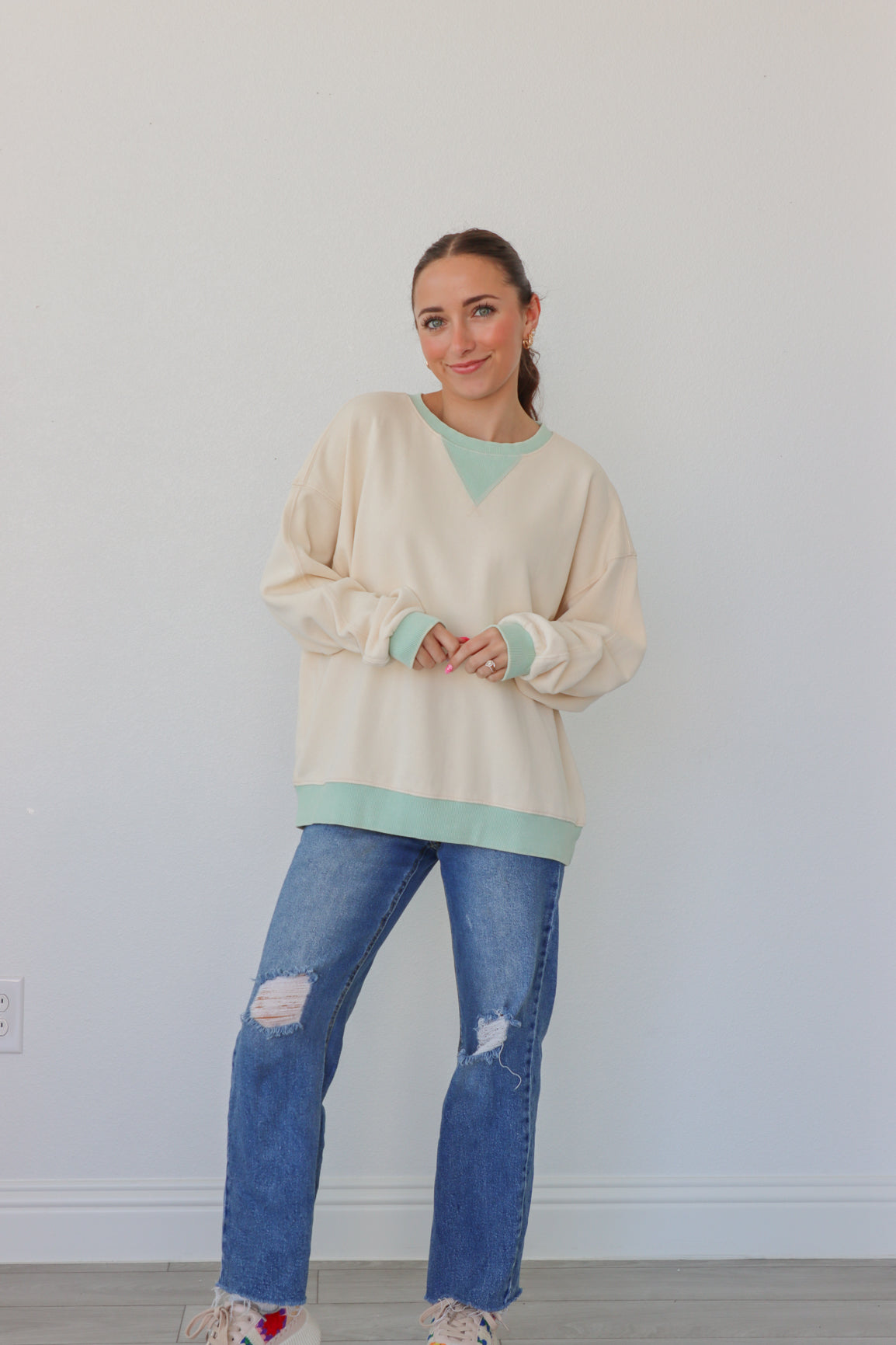 girl wearing cream longsleeve top with light blue detailing