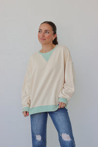 girl wearing cream longsleeve top with light blue detailing