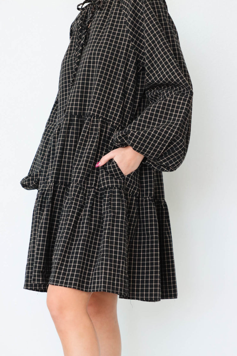 girl wearing black plaid long sleeve dress