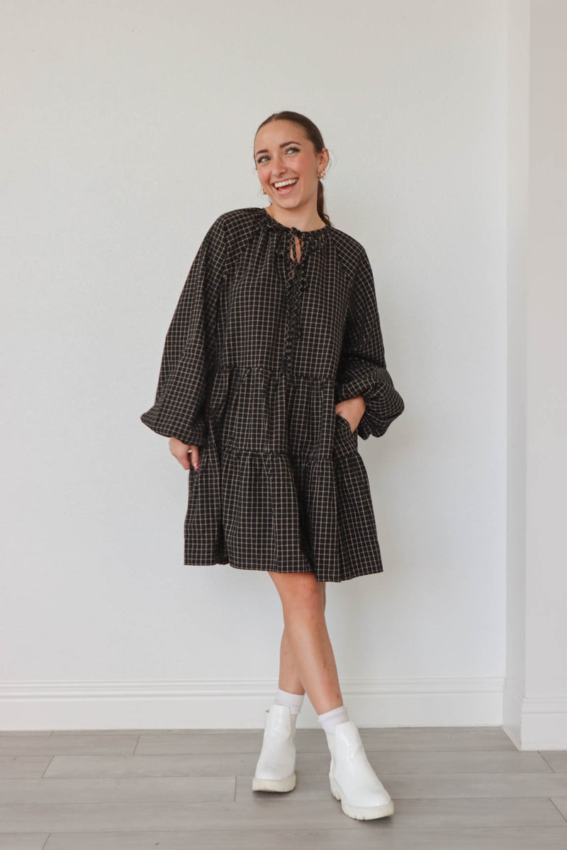 girl wearing black plaid long sleeve dress