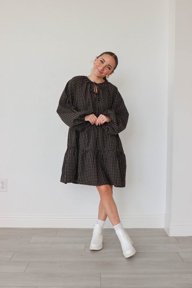 girl wearing black plaid long sleeve dress