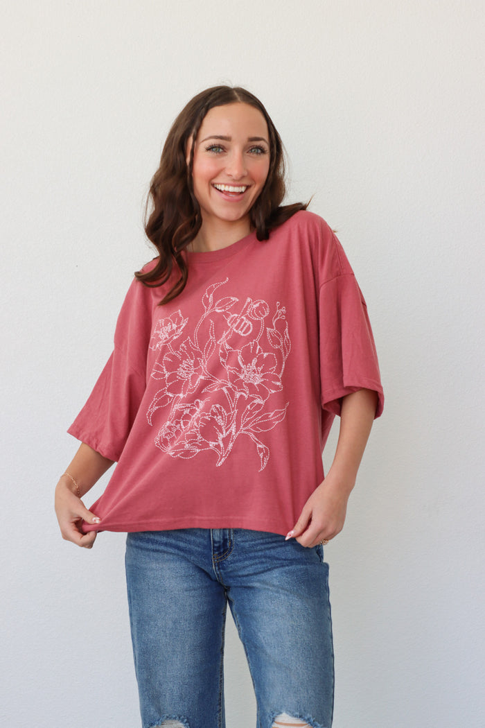 girl wearing pink t-shirt with white floral graphic