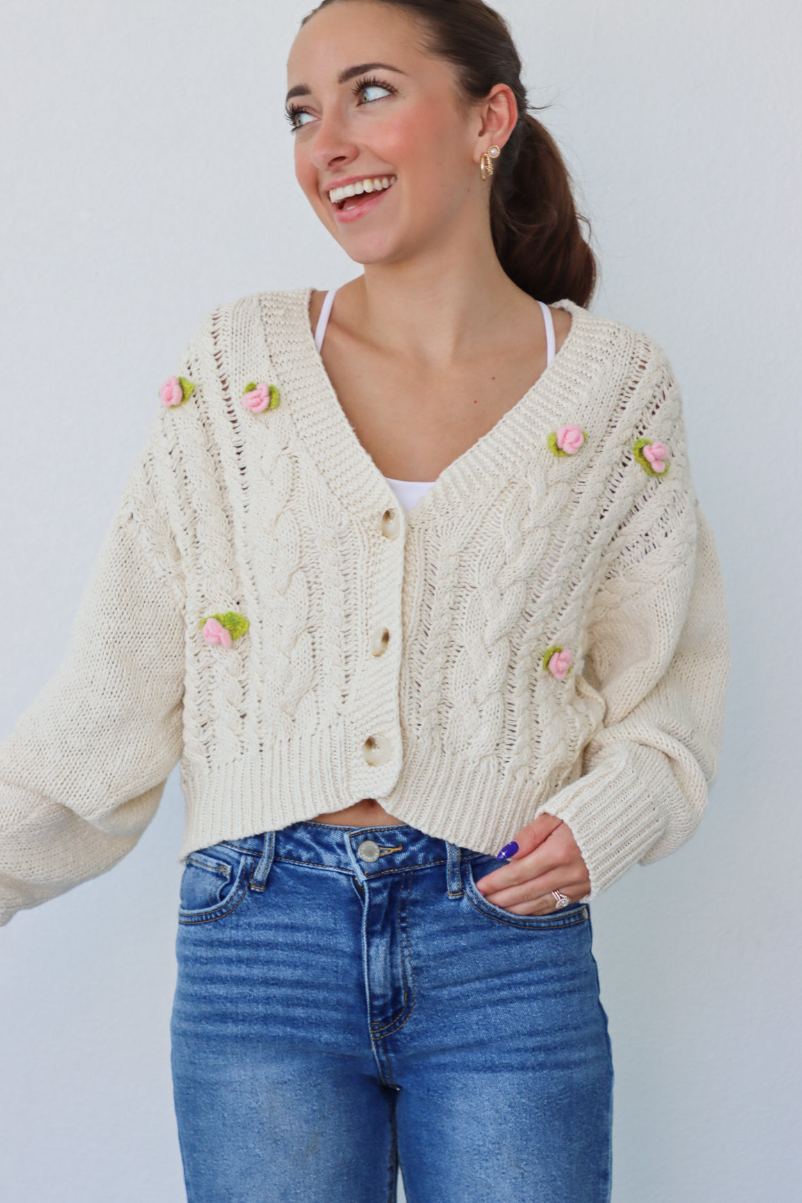 girl wearing cream cardigan with pink crochet flowers