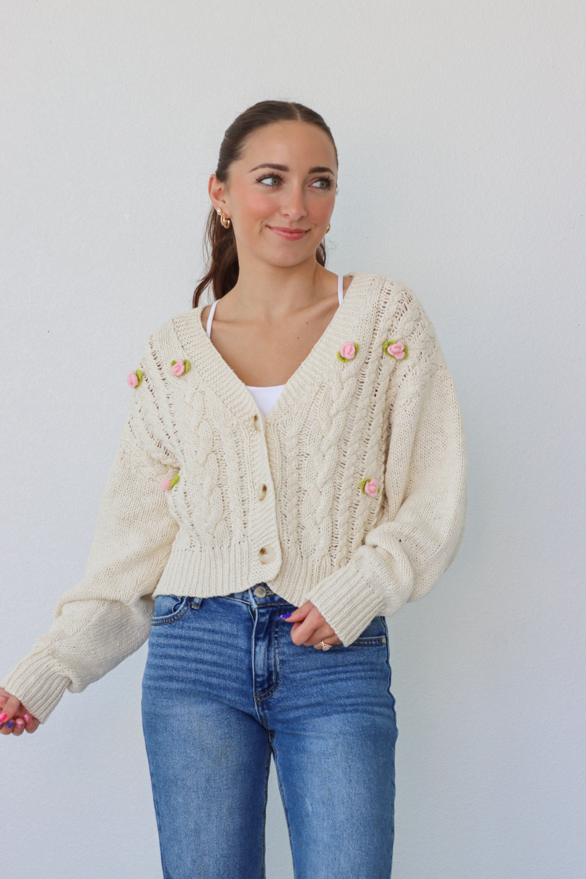 girl wearing cream cardigan with pink crochet flowers