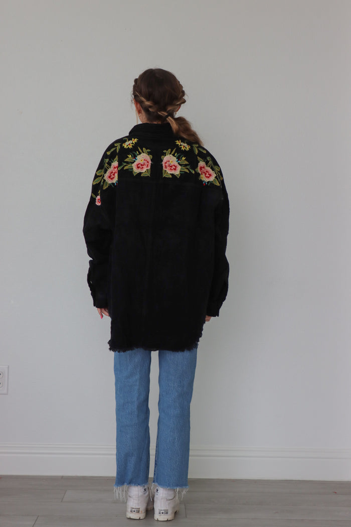 girl wearing black corduroy jacket with floral embroidered detailing