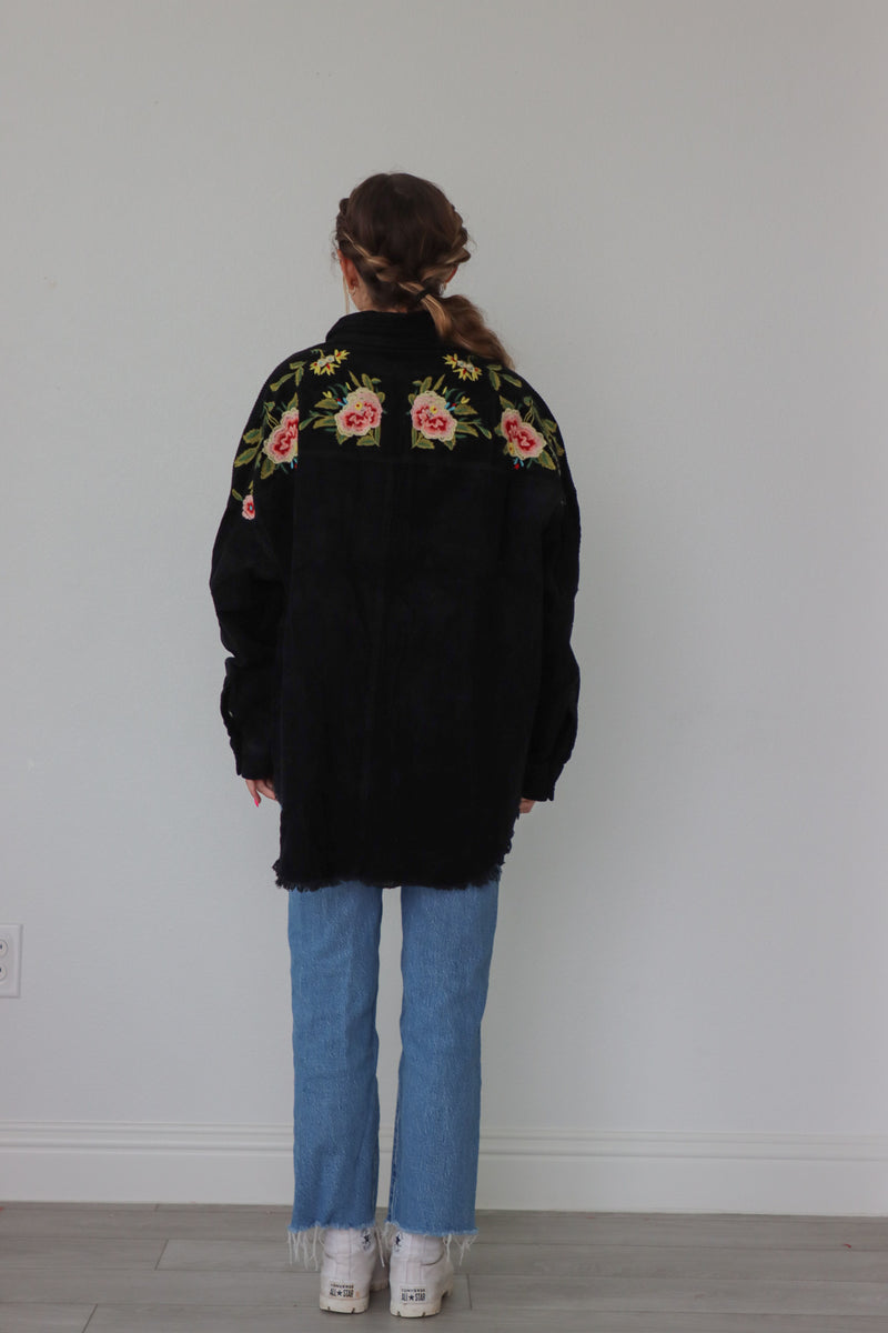 girl wearing black corduroy jacket with floral embroidered detailing