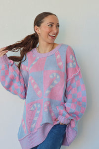 girl wearing periwinkle and pink candy cane sweater