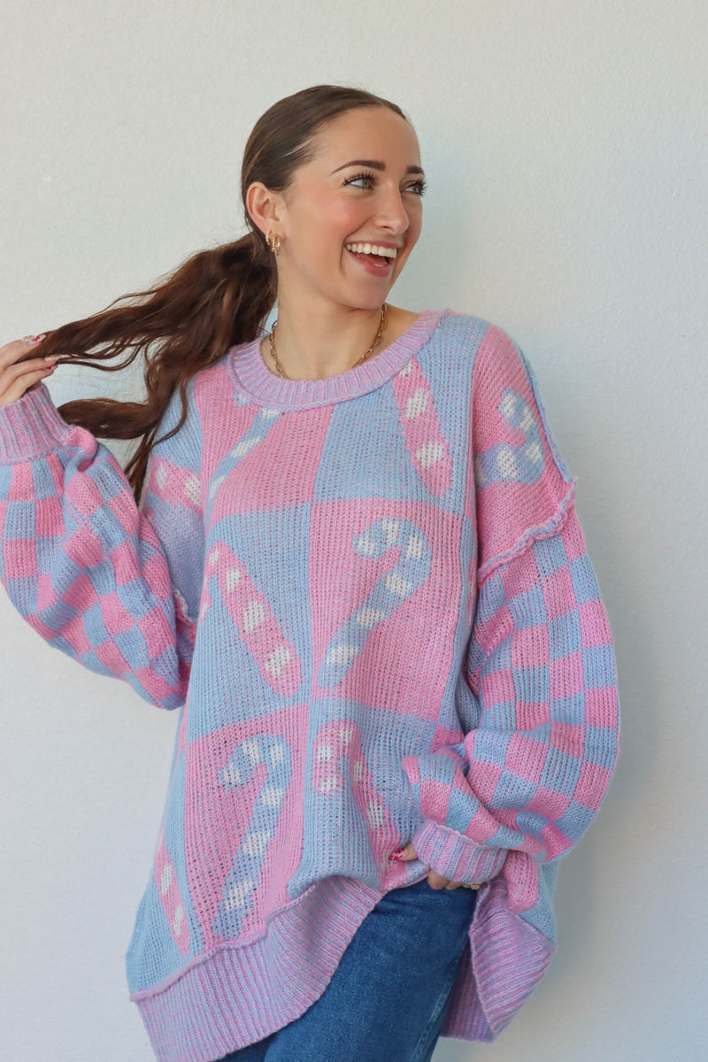 girl wearing periwinkle and pink candy cane sweater