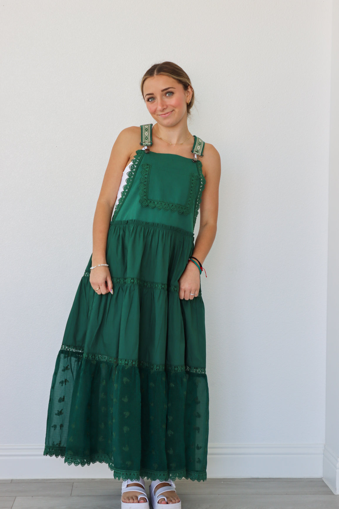 girl wearing dark green overall dress