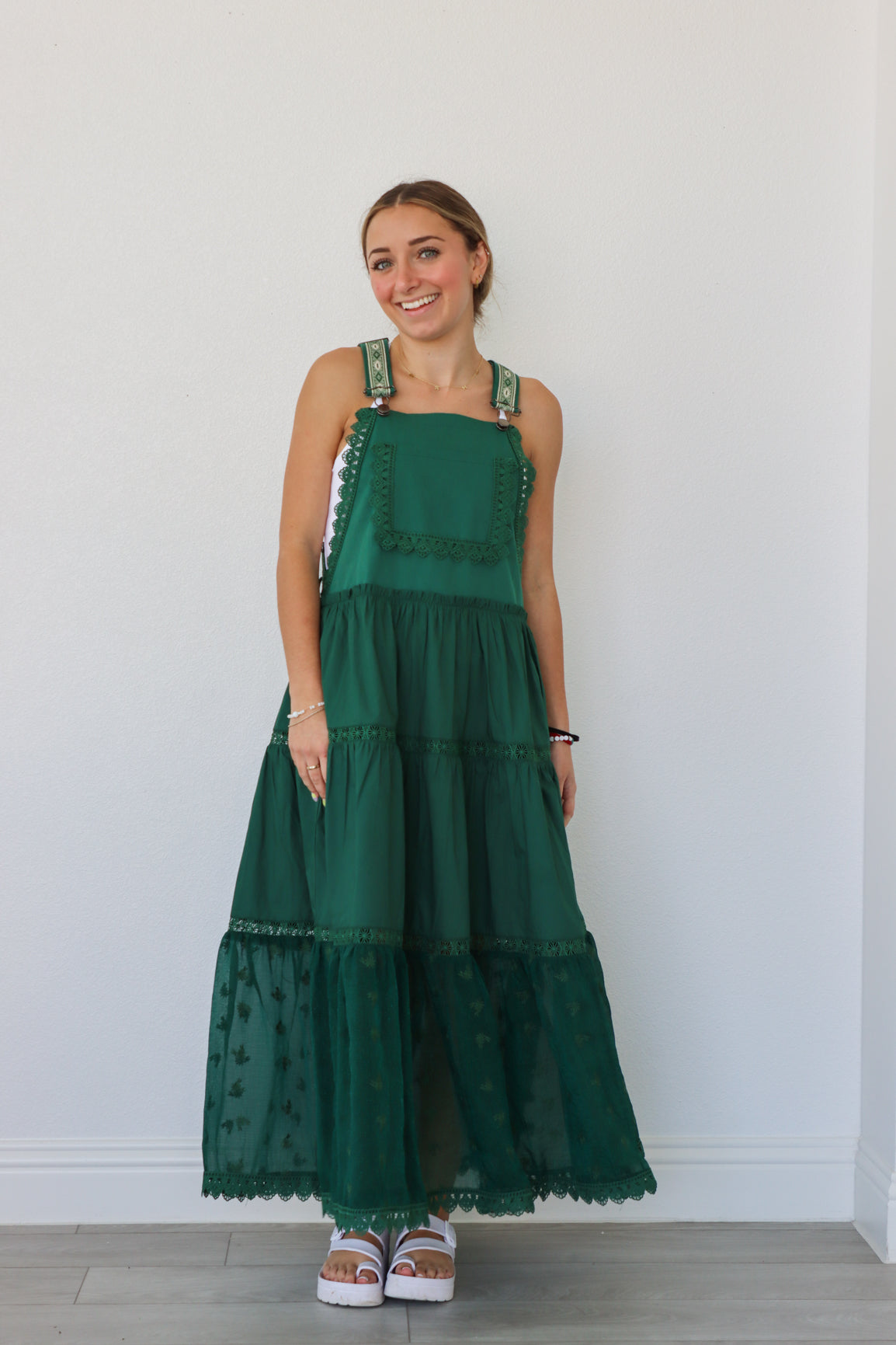 girl wearing dark green overall dress