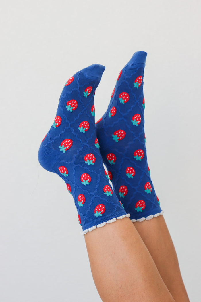girl wearing blue strawberry socks