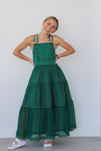 girl wearing dark green overall dress