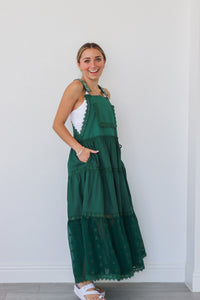 girl wearing dark green overall dress