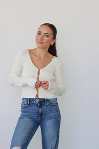 girl wearing cream cardigan with flower buttons