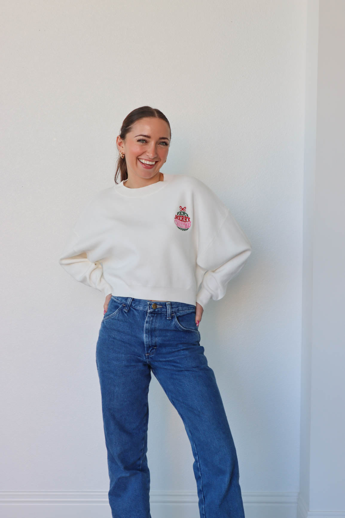 girl wearing white "very merry christmas" sweater